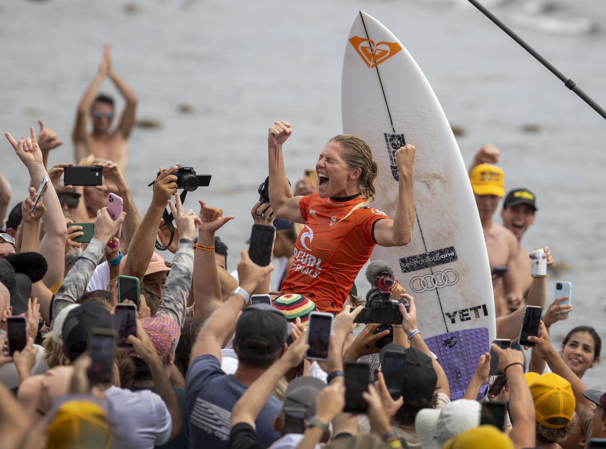 Stephanie Gilmore is carried up the beach as she celebrates her eighth world title.