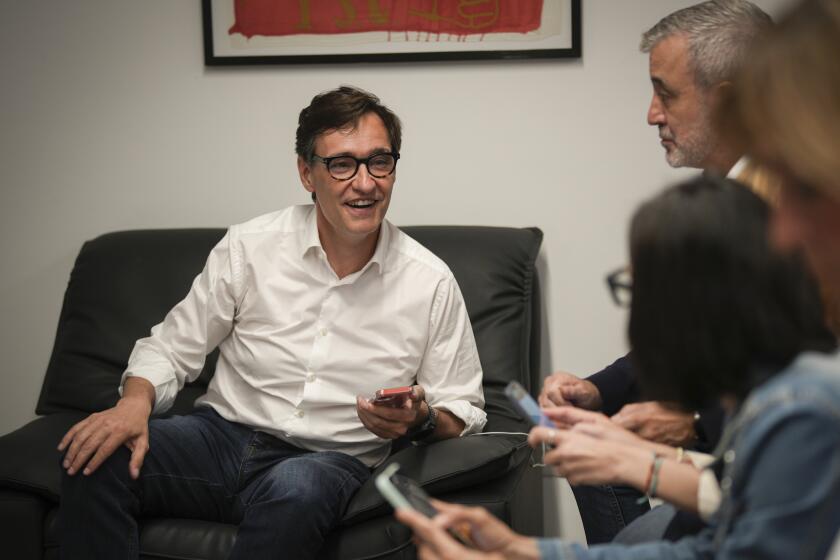 Socialist candidate Salvador Illa talks with party colleagues as they wait for election results at the party headquarters in Barcelona, Sunday May 12, 2024. Catalonia is holding a regional election on Sunday whose outcome will be a test both for the strength of the separatist movement and for the policies of Prime Minister Pedro Sánchez.(AP Photo/Emilio Morenatti)