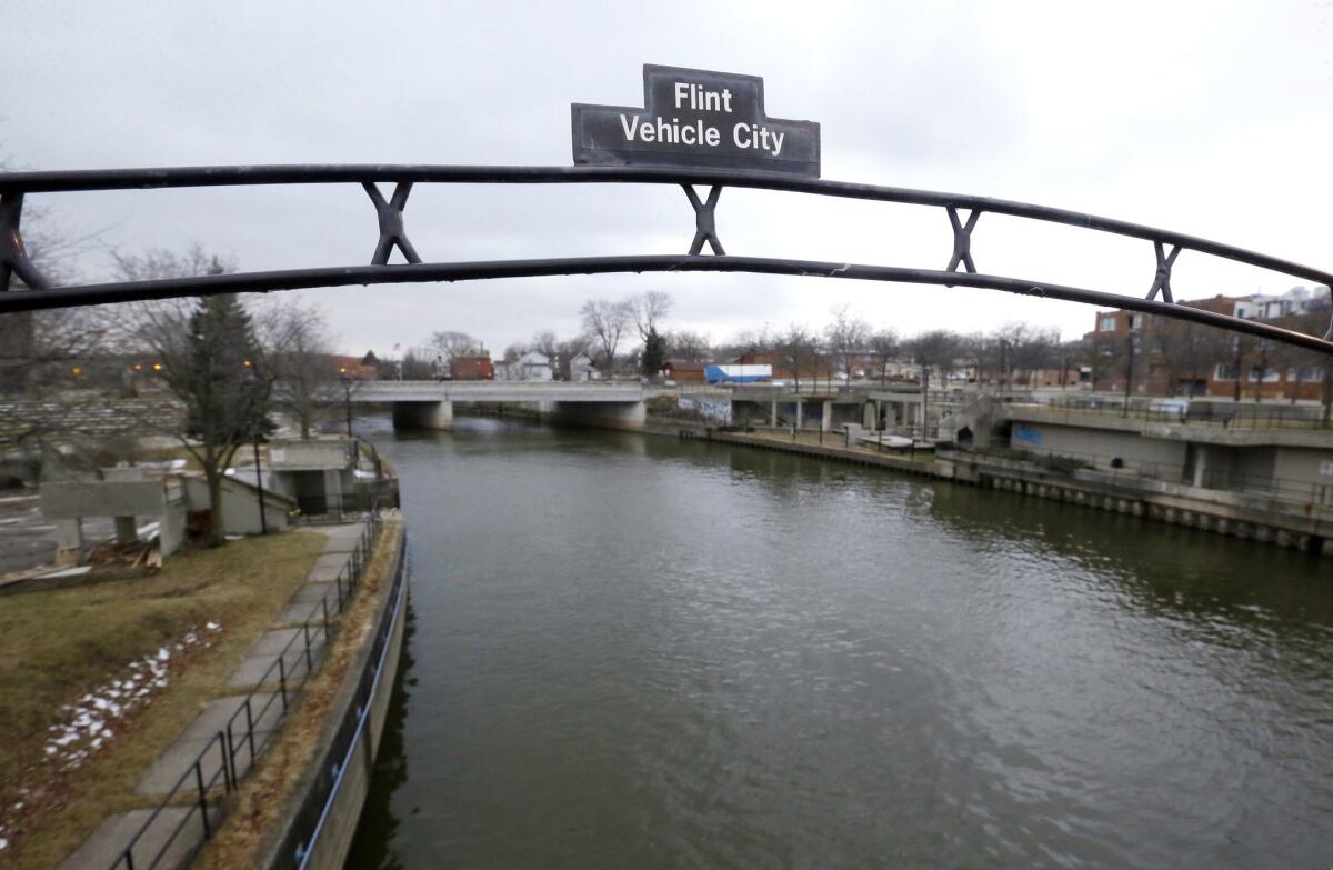 A sign over the Flint River notes Flint, Mich., as Vehicle City in January.