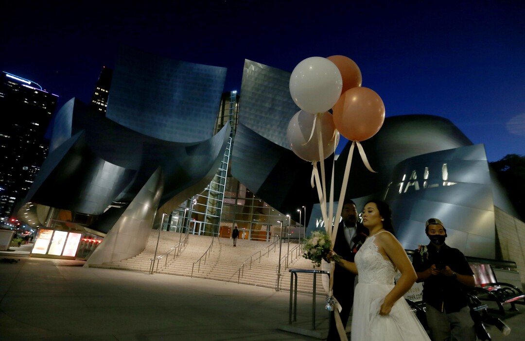 Newlyweds have their picture taken at the Walt Disney Concert Hall in downtown Los Angeles.