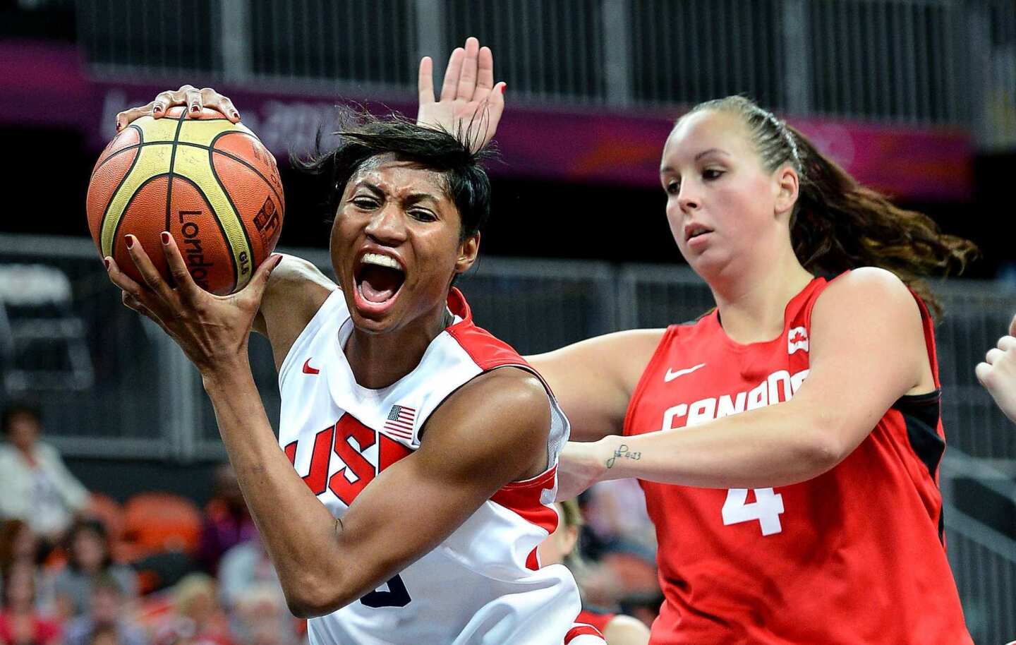 United States' Angel McCoughtry grabs an offensive rebound from Canada's Krita Phillips.