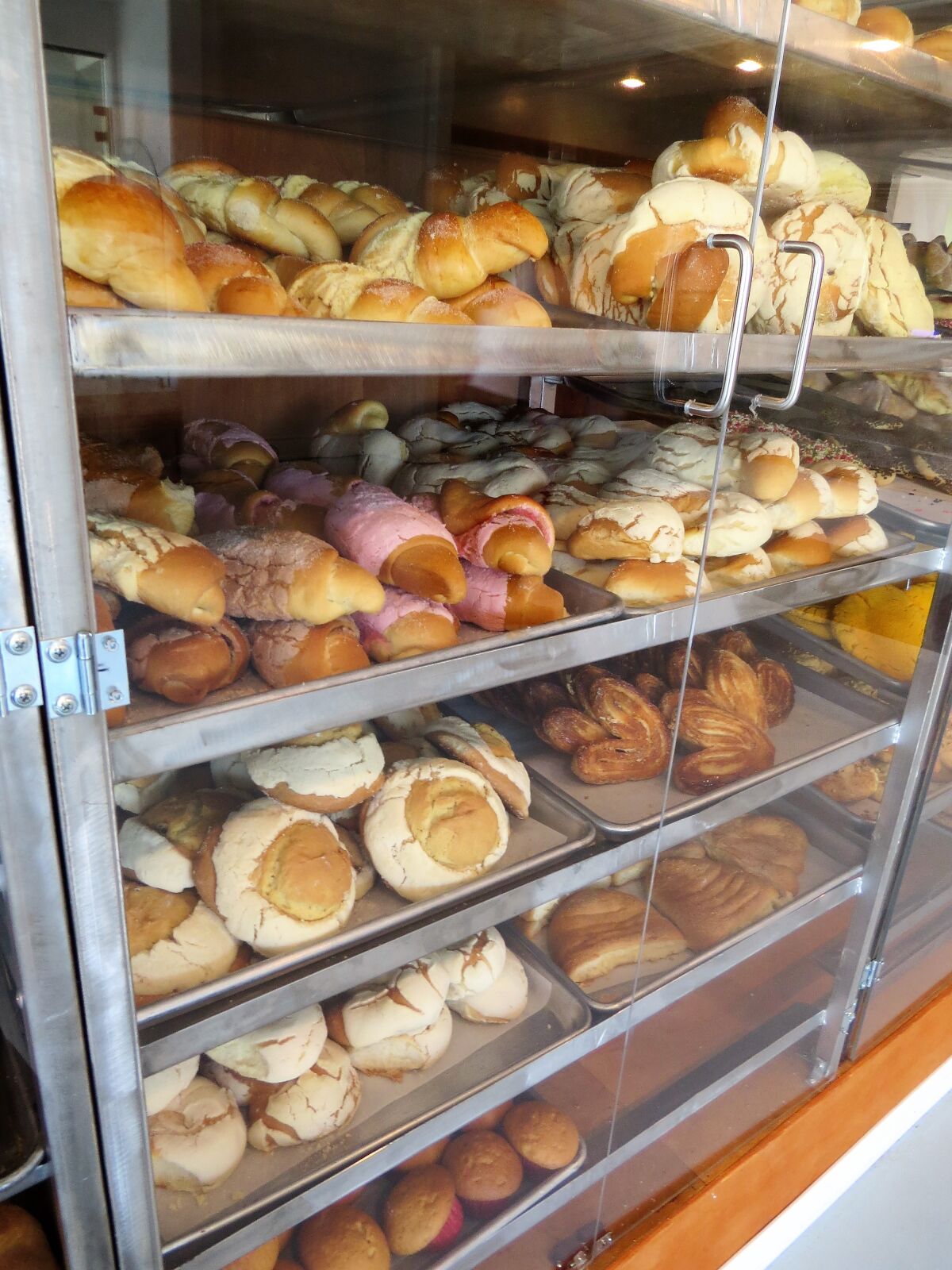 Customers can grab a tray and tongs and help themselves to a wide selection of Mexican pan dulce at Camila's Bakery in Escondido.