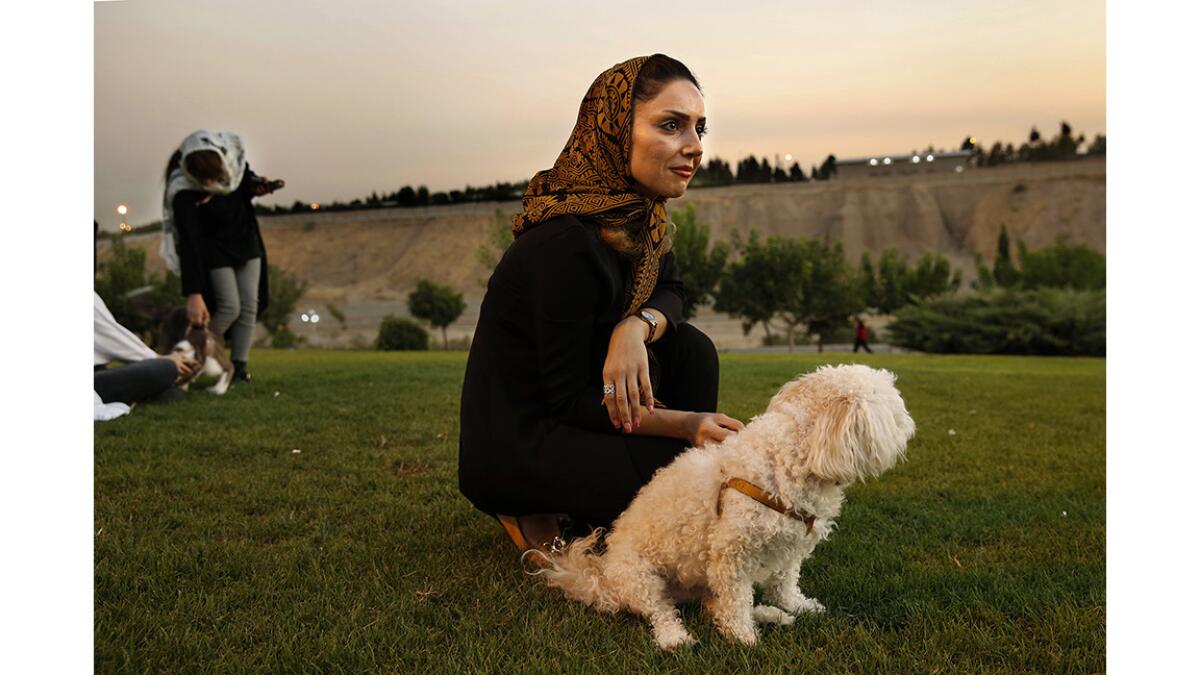 Susan Mokhtiari, 39, in a Tehran park with her terrier Rubeena.