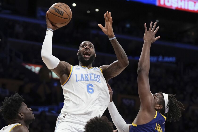Los Angeles Lakers forward LeBron James, center, shoots as Golden State Warriors forward Kevon Looney.