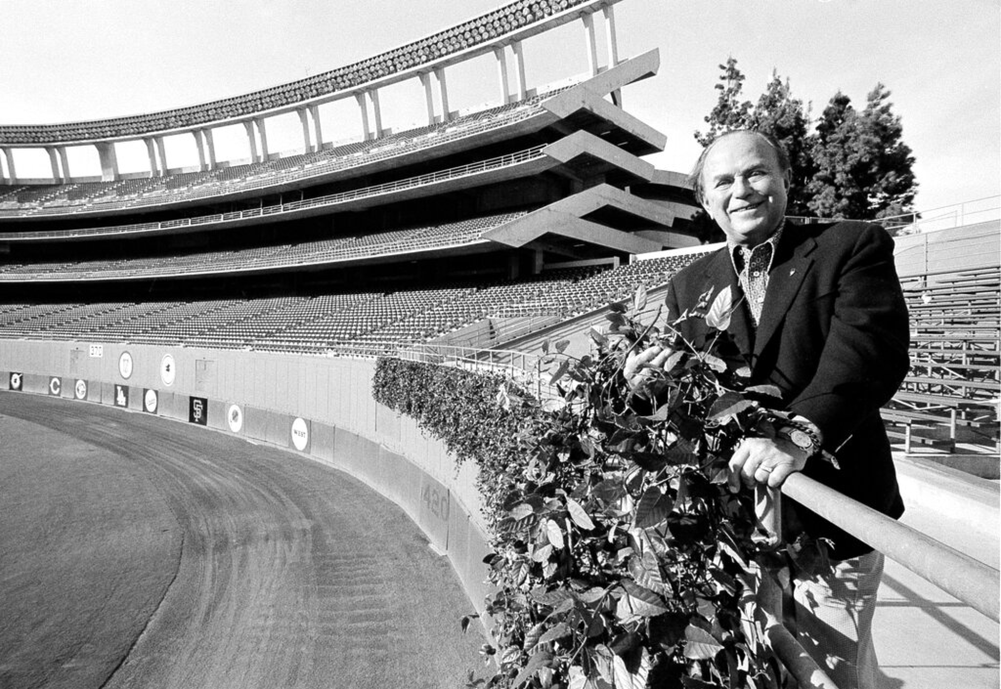 Ray Kroc, owner of the San Diego Padres, stands next to his ivy curtain covering the center field fence at San Diego Stadium.