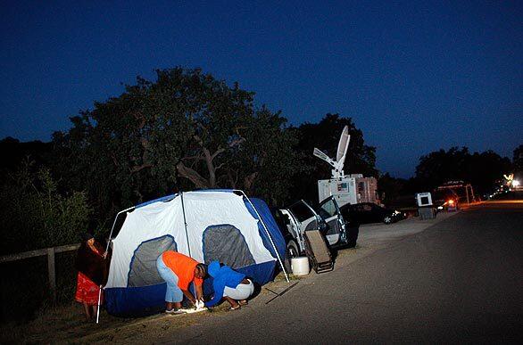 Karless Osby, left, Desiree Crossley, and Desiree Bell set up their tent on the side of the road near the gates of Neverland Ranch, Michael Jackson's former residence, where they spent the night after traveling from Lancaster to join the vigil for the dead entertainer.