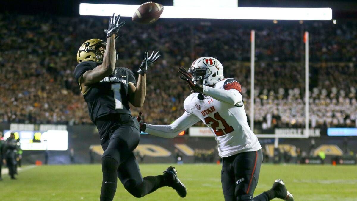 Colorado receiver Shay Fields catches a touchdown pass while being defended by Utah defensive back Tyrone Smith during their game Saturday.