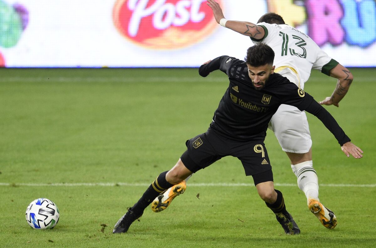Los Angeles FC forward Diego Rossi, front, and Portland Timbers defender Dario Zuparic battle for the ball.