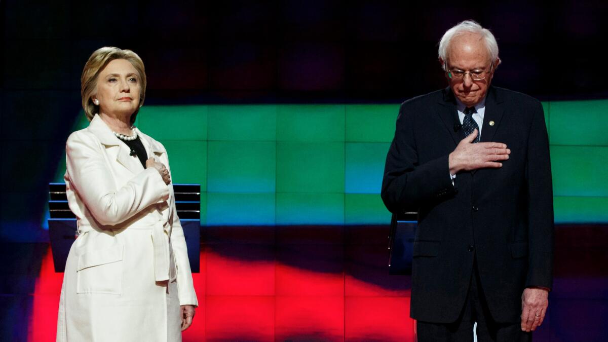 Hillary Clinton and Bernie Sanders standing during the National Anthem at the start of a debate at the Brooklyn Navy Yard in Brooklyn, New York on April 14.