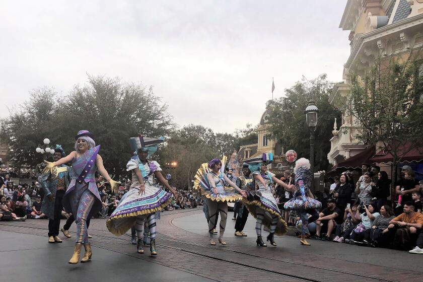 Costumed dancers interact with park-goers in the premiere of the Magic Happens parade at Disneyland Park on Feb. 28.