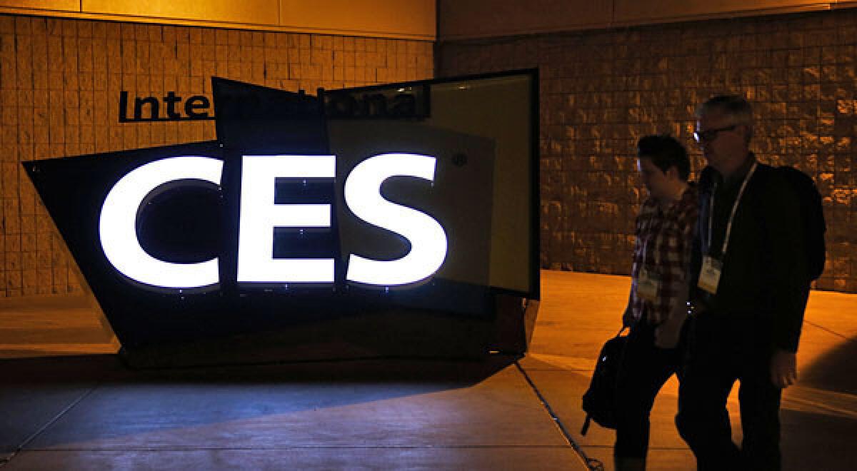 Attendees walk past signage illuminated outside the Las Vegas Convention Center during the 2014 Consumer Electronics Show (CES) in Las Vegas, Nevada, U.S., on Monday, Jan. 6, 2014. The CES trade show, which runs until Jan. 10, is the world's largest annual innovation event that offers an array of entrepreneur focused exhibits, events, and conference sessions for technology entrepreneurs. Photographer: Patrick T. Fallon/Bloomberg ** Usable by CT and LA Only **