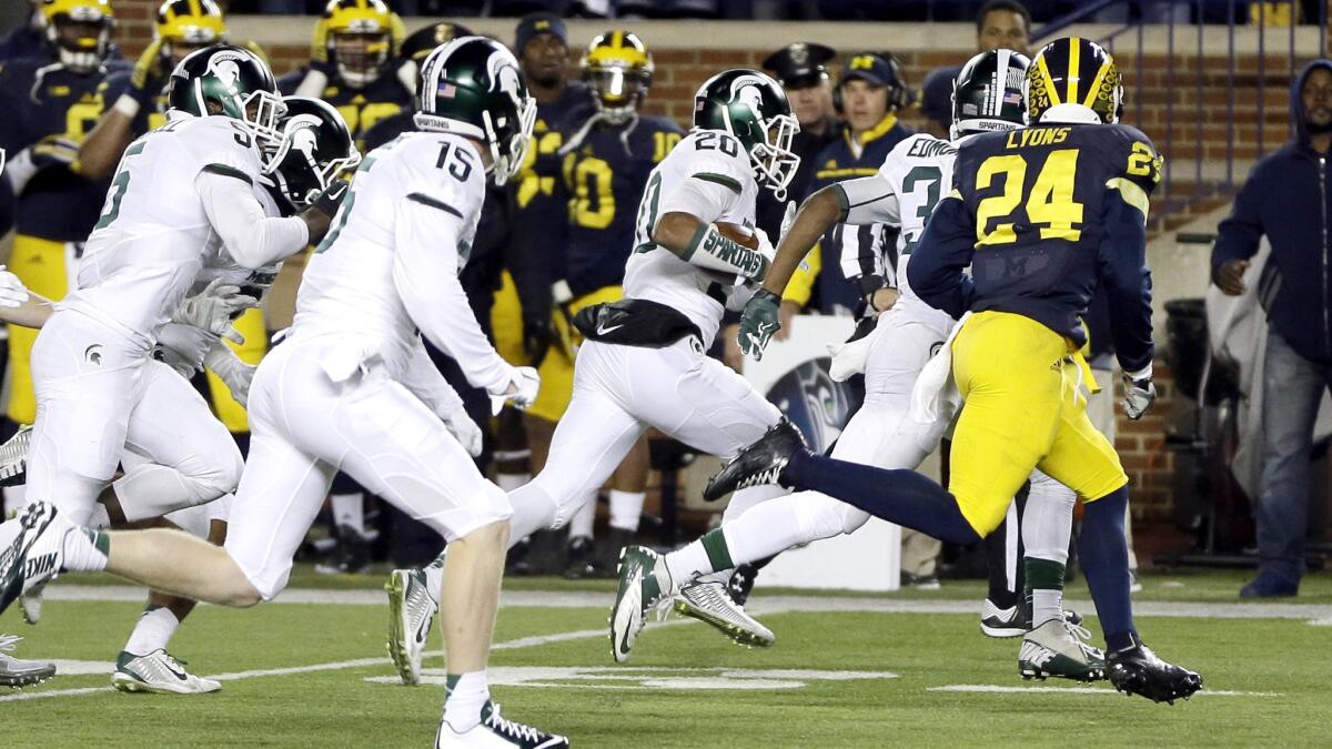 Michigan State defensive back Jalen Watts-Jackson (20) runs returns a fumbled punt attempt by Michigan for the winning touchdown on the game's final play Saturday.