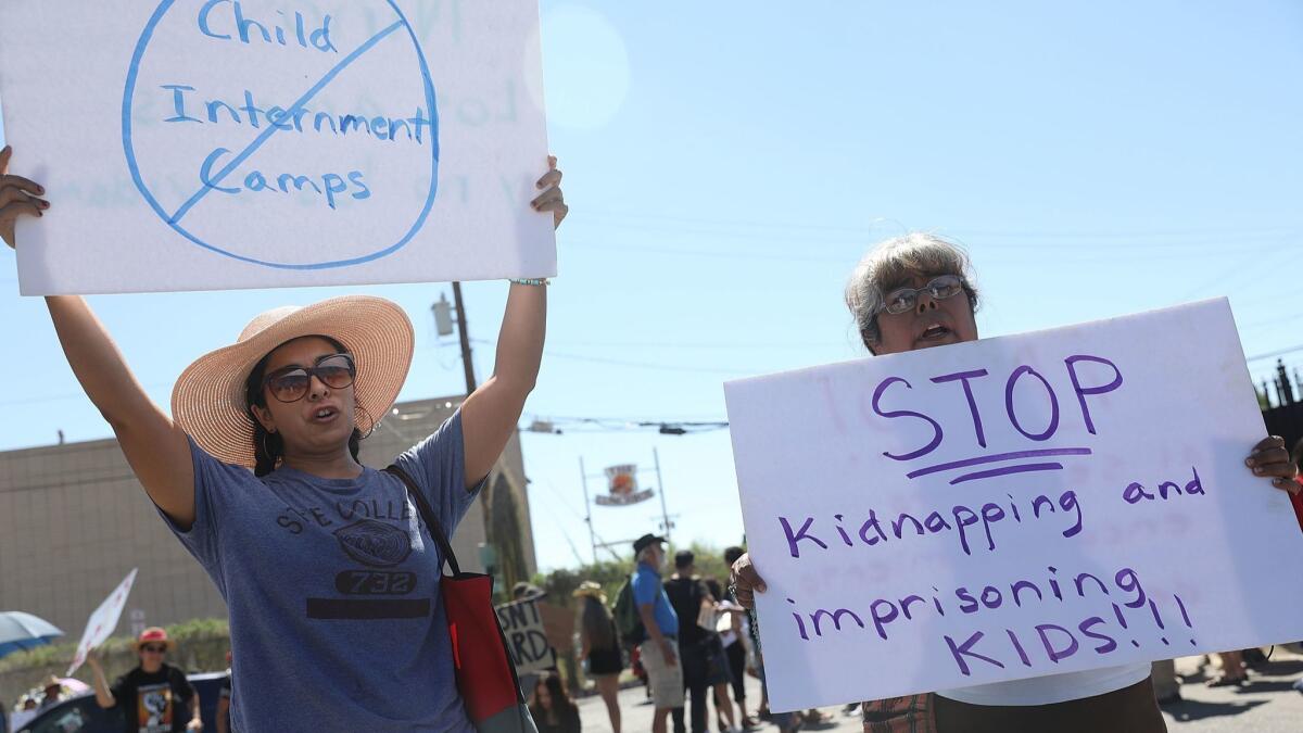 Noelle Andrade, left, and her mother, Armida Hernandez, protest the separation of children from their parents in front of the El Paso Processing Center, an immigration detention facility.