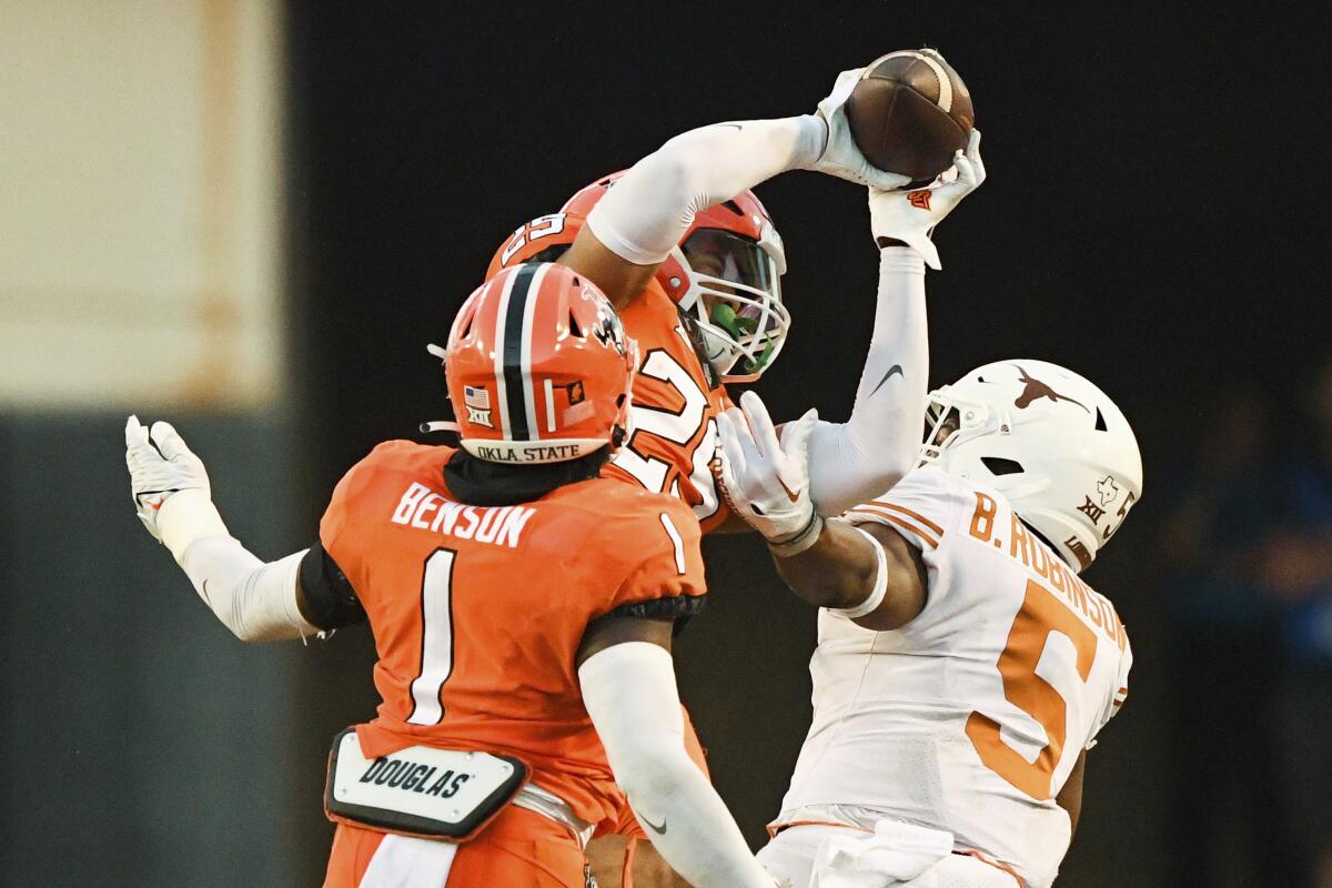 Oklahoma State safety Jason Taylor II (25) intercepts a pass intended for Texas running back Bijan Robinson (5).