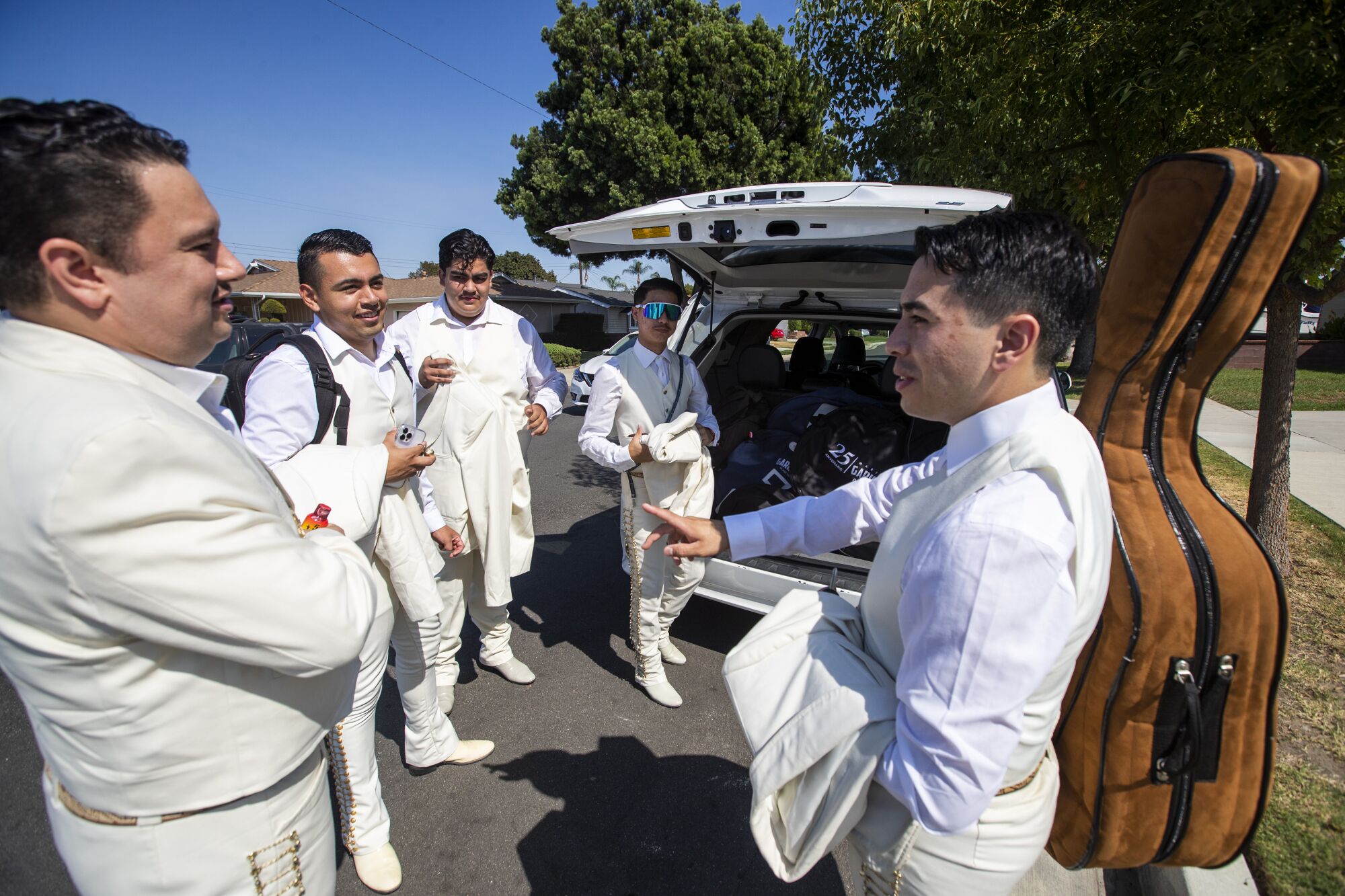 Les membres de Mariachi Garibaldi de Jaime Cuellar chargent dans la camionnette alors qu'ils font du covoiturage jusqu'au Dodger Stadium