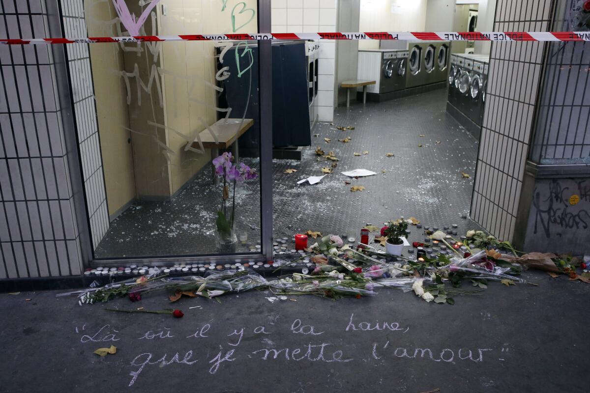 Un mensaje en el pavimento dice: "Donde hay odio yo quiero traer amor", cerca de las veladoras y flores en el lugar de los atentados en rue de la Fontaine au Roi, en París, Francia.