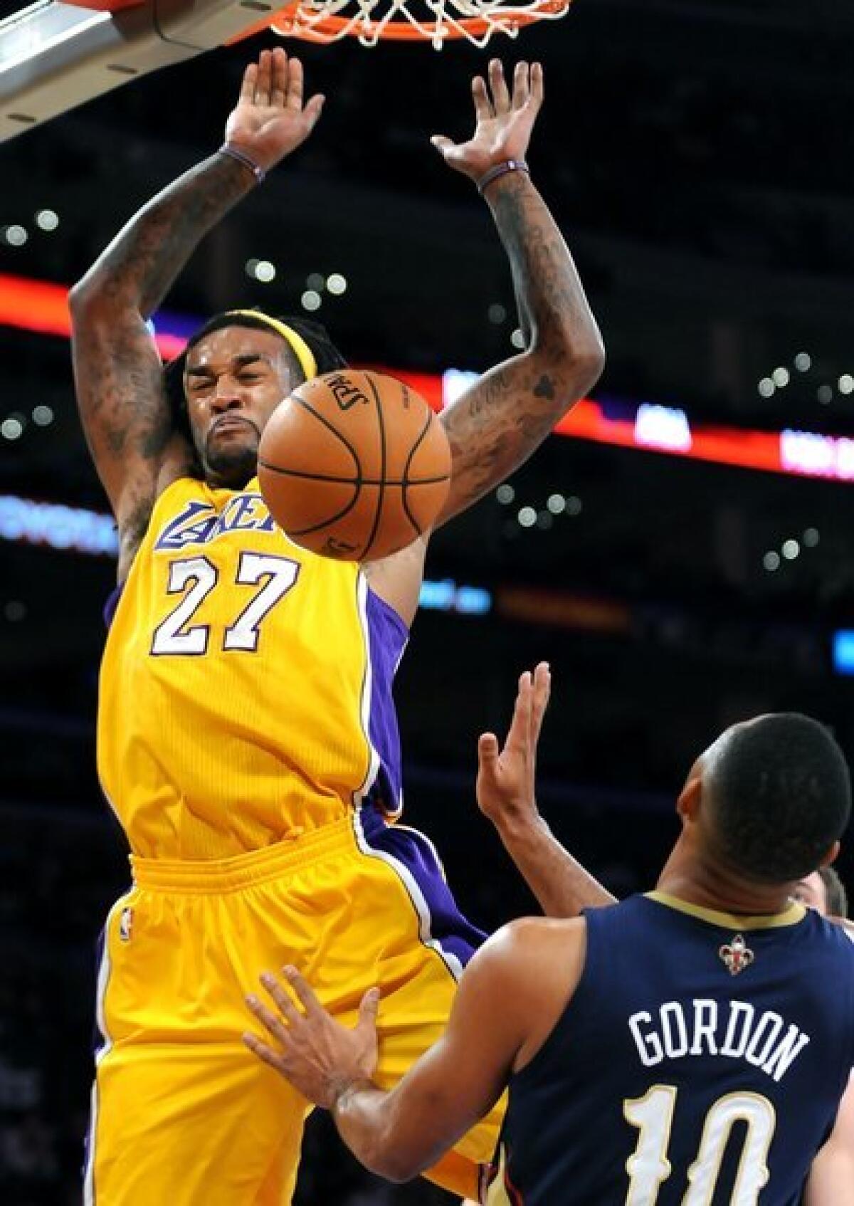 Jordan Hill dunks over Eric Gordon during the Lakers' win over the New Orleans Pelicans, 116-95, on Tuesday at Staples Center.