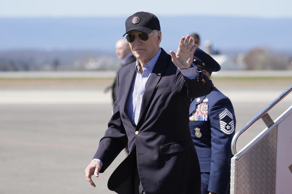 President Biden waves as he deplanes from Air Force One.
