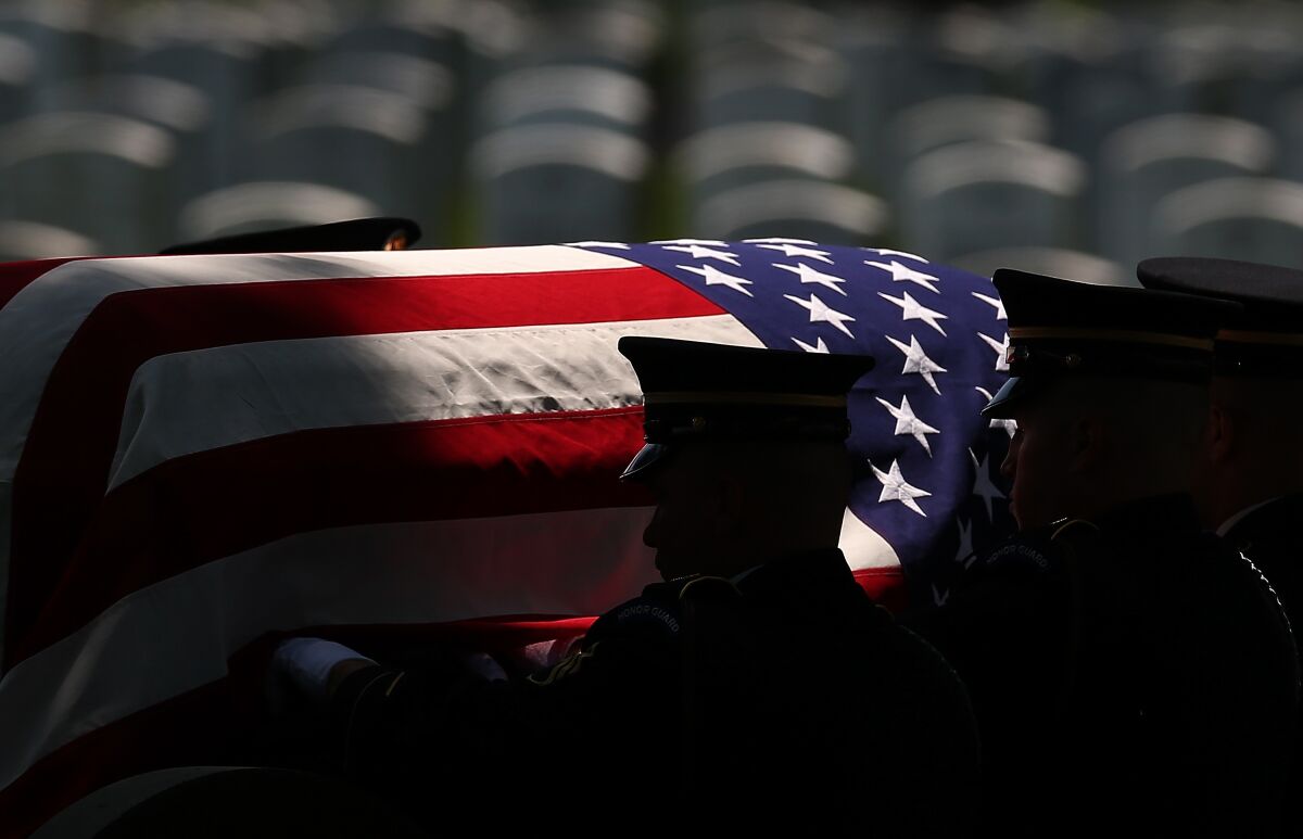 Members of a U.S. Army burial team carry a casket containing the remains of a World War II U.S Army Air Forces 2nd Lt.