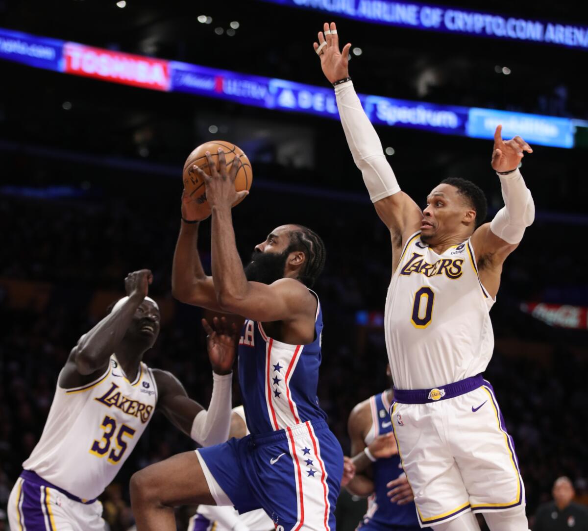 Philadelphia guard James Harden, center, tries to score against the Lakers' Wenyen Gabriel, left, and Russell Westbrook.