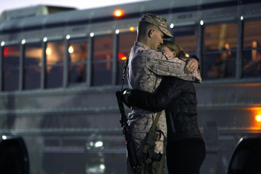 A young Marine and his wife embrace moments before the sunrise departure of the 1st Marine Expeditionary Force from Camp Pendleton on Monday.