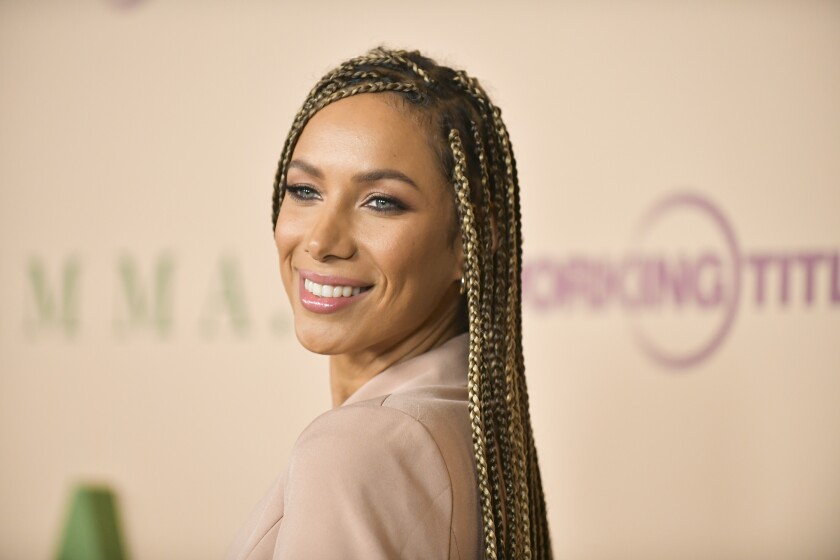 A woman with braids smiles for a portrait