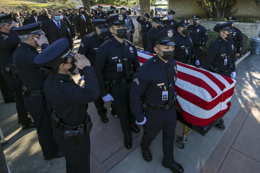 Pallbearers carry the casket of LAPD Officer Fernando Arroyos at Forest Lawn-Hollywood Hills.