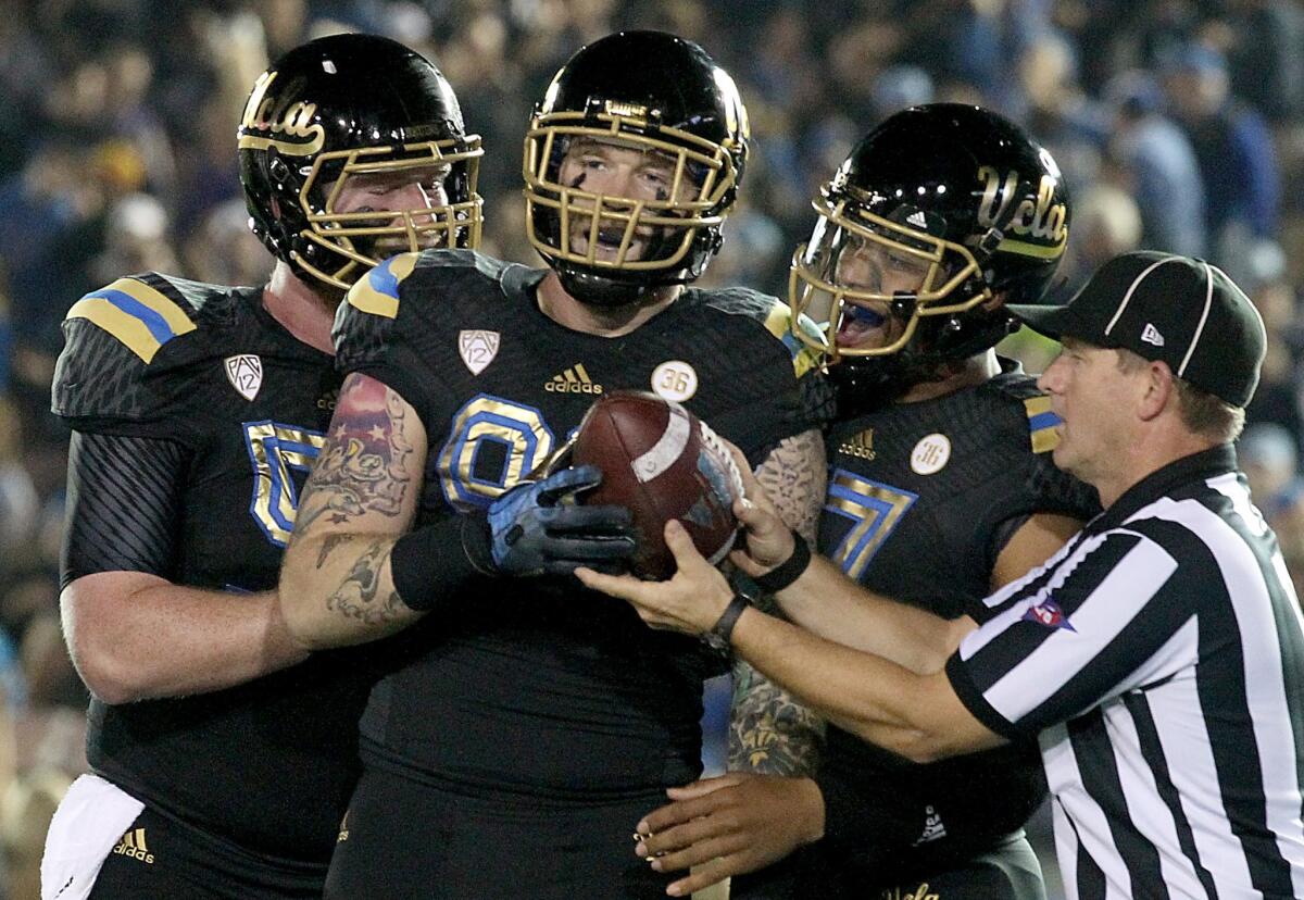 UCLA center Jake Brendel, left, Cassius Marsh and Brett Hundley celebrate Marsh's touchdown catch against the Washington Huskies last season. Brendel suffered a sprained knee in practice two weeks ago and it is unclear if he'll be available for the Bruins' first game.