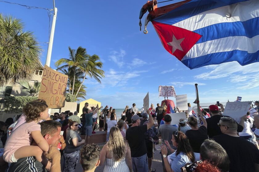 Roughly two hundred supporters of recent protests in Cuba gather at the Southernmost Point buoy in Key West, Florida, on July 13, 2021. Carrying signs demanding freedom for the Cuban people, the crowd paraded down Duval Street following an over-sized Cuban flag provided by a local tow truck company. (Rob O'Neal/The Key West Citizen via AP)