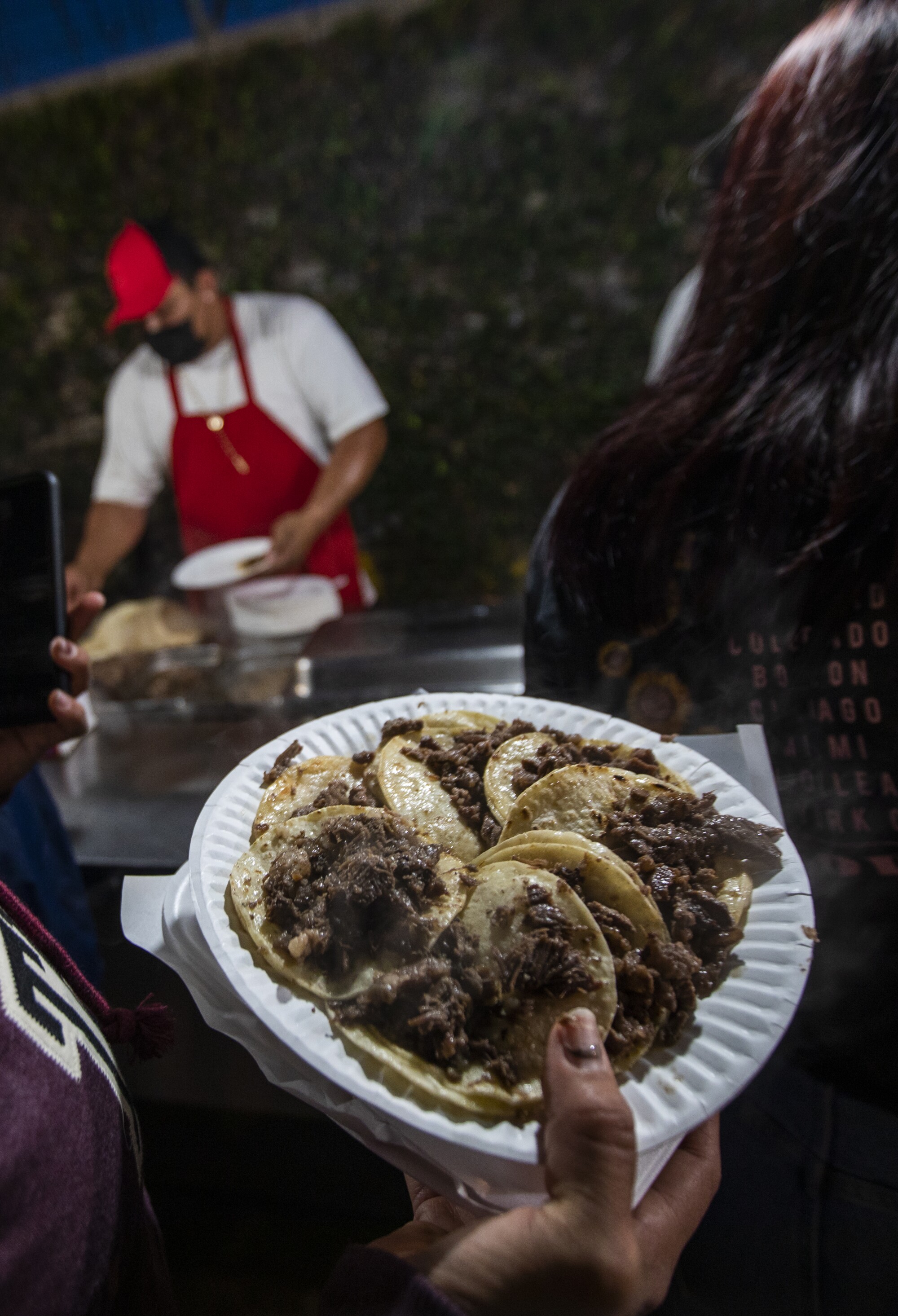 A paper plate with several tacos.