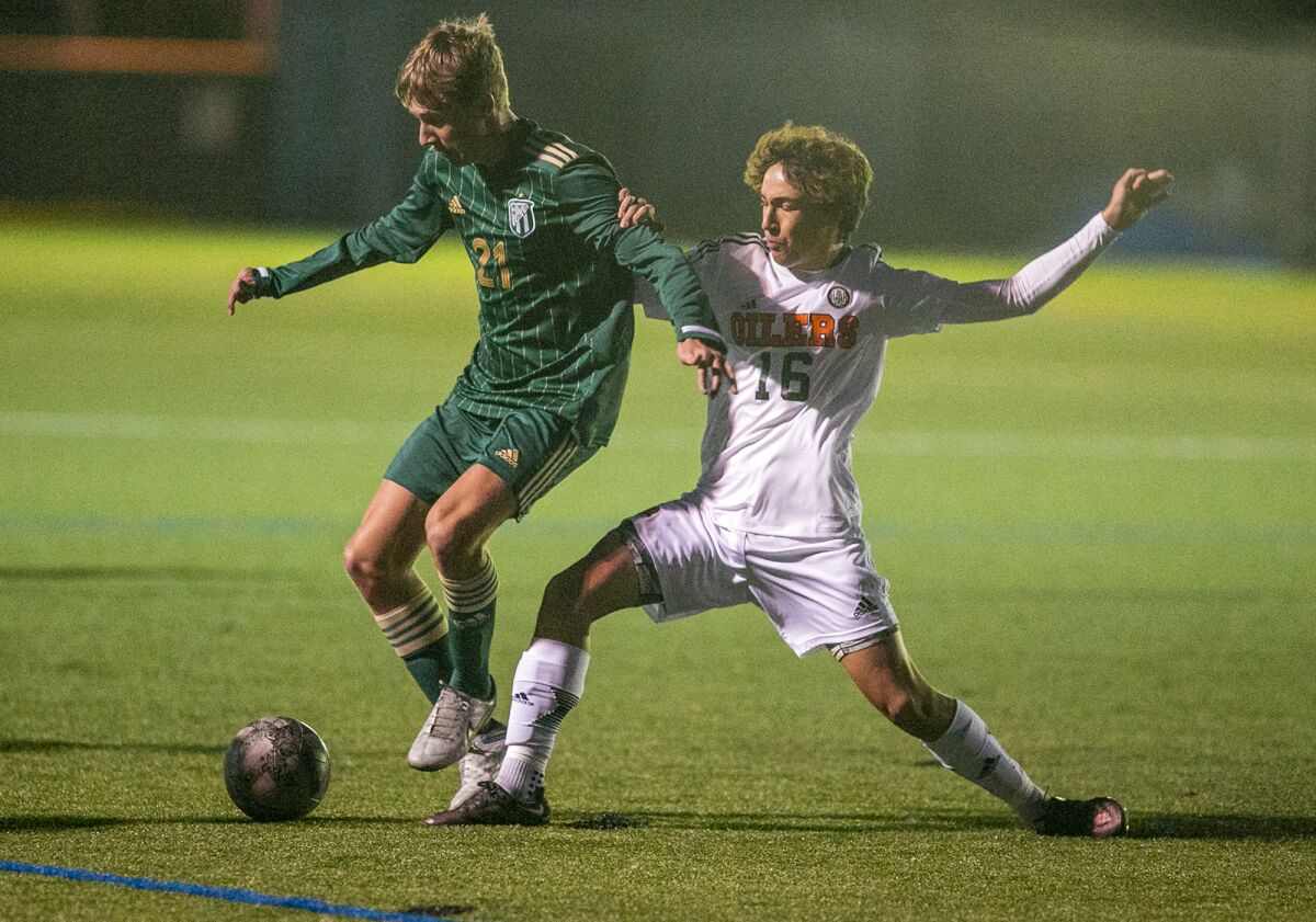 Edison's Wyatt Bellinger and Huntington Beach's Jonathan Finemel battle for a ball during a Surf League match on Wednesday.
