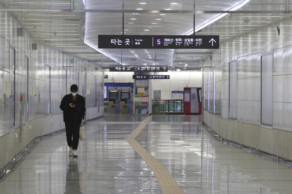 A man wearing a face mask walks alone at a subway station in Seoul, South Korea, where infections soared past 3,500 this week.