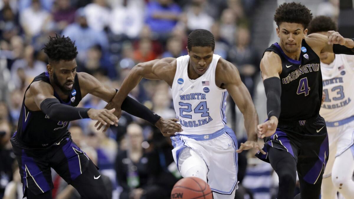 North Carolina's Kenny Williams, center, chases after a loose ball ahead of Washington's Jaylen Nowell, left, and Matisse Thybulle during the Tar Heels' second-round win in the NCAA tournament on Sunday.
