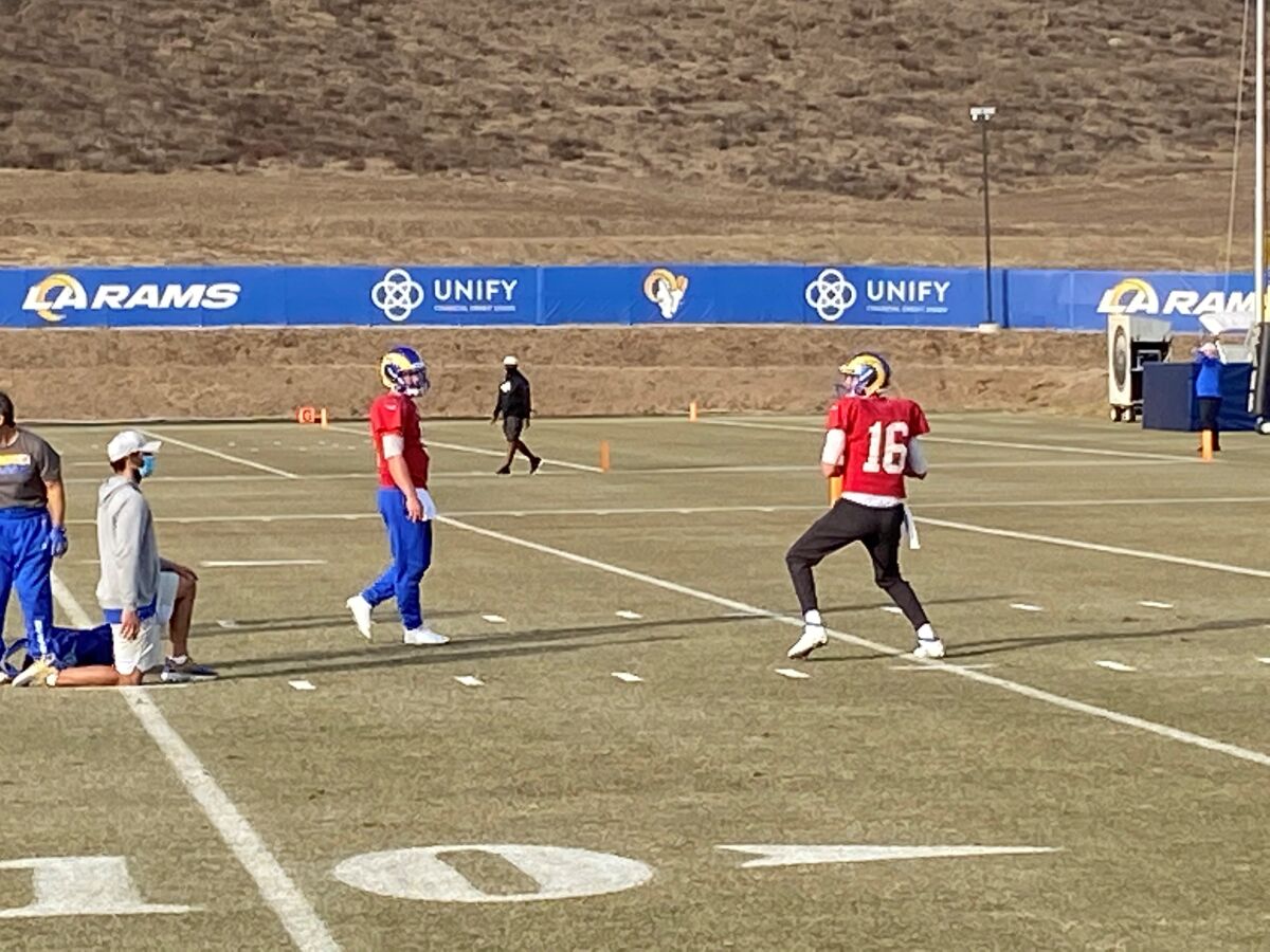 Rams quarterback Jared Goff throws while John Wolford watches.