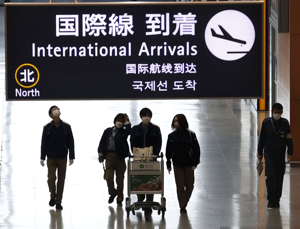 Passengers walking through lobby of Japanese airport