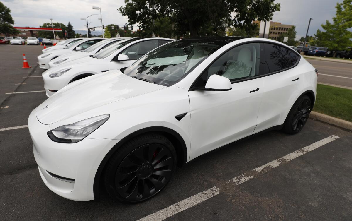 A long line of unsold Model Y sports utility vehicles sits at a Tesla dealership in Littleton, Colo. 