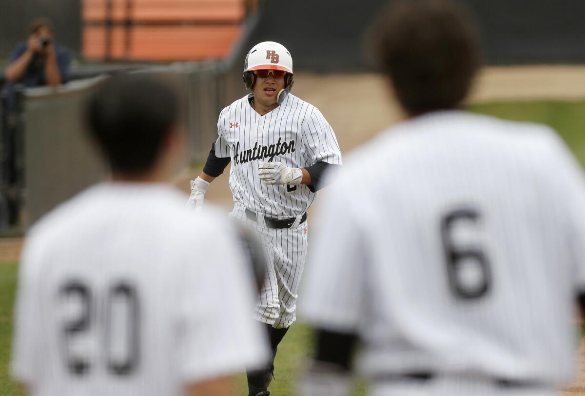 Huntington Beach High's Cole Minato (2) jogs to home plate after he hit a two-run homer during the first inning against Laguna Beach in a Sunset Conference crossover game on Friday.