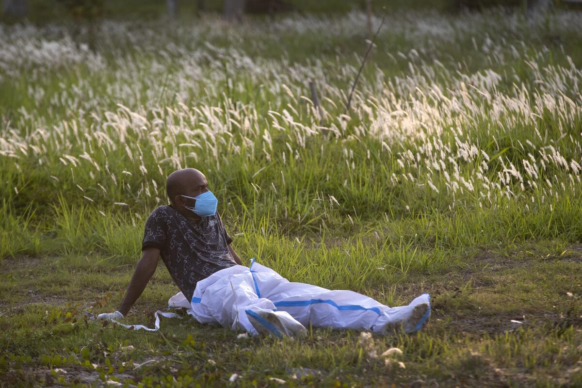 An exhausted municipal worker rests in a field