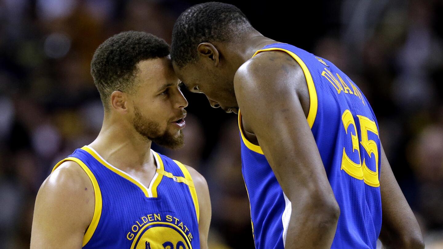 Warriors guard Stephen Stephen Curry, left, and forward Kevin Durant bump foreheads in the final moments of a come-from-behind victory over the Cavaliers in Game 3.