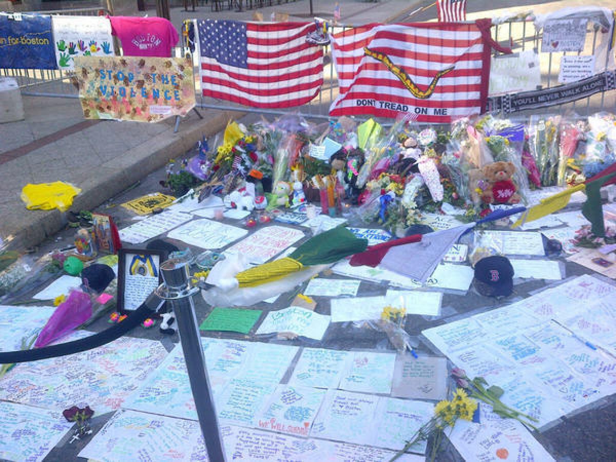 A memorial grows at the Boston Marathon finish line. Running shoes, a finisher's medal and Red Sox souvenirs were among the items left.