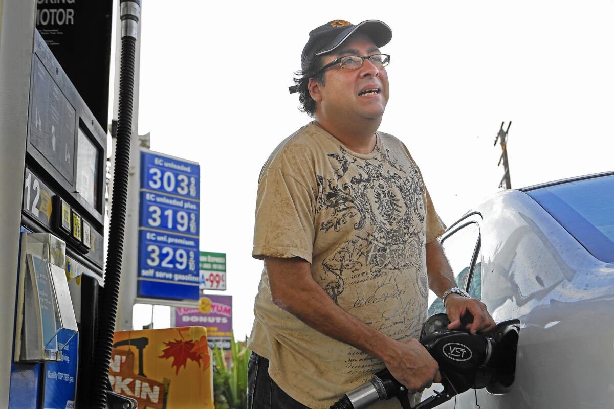 Antonio Briceno, 46, pumps gas into his Toyota Corolla at an Arco station as the price of gas continues to drop in the Southland.