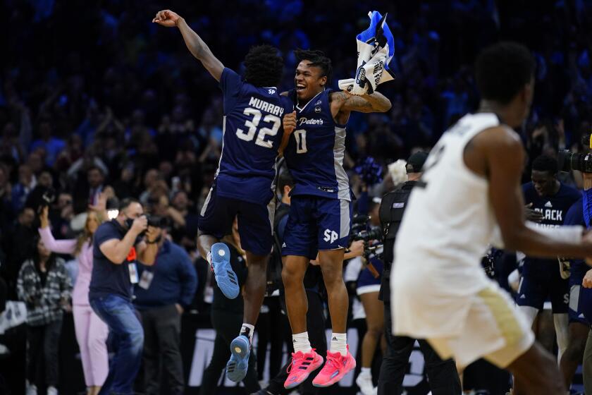 Saint Peter's Jaylen Murray, left, and Latrell Reid celebrate after Saint Peter's won a college basketball game.