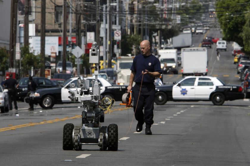 A police officer uses a robot to investigate a bomb threat in San Francisco, on July 25, 2008. The liberal city of San Francisco became the unlikely proponent of weaponized police robots on Tuesday, Nov. 29, 2022, after supervisors approved limited use of the remote-controlled devices, addressing head-on an evolving technology that has become more widely available even if it is rarely deployed to confront suspects. (Michael Macor/San Francisco Chronicle via AP)