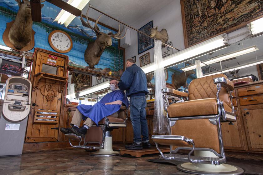 Oceanside, CA - May 07: Adam Lyttle gets a hair cut by Johnny Gomez at Esquire Barber Shop in Oceanside. Lyttle has been going to Esquire since the 80's. Gomez has been cutting hair at Esquire for a mostly military clientele since 1960. (Jarrod Valliere / The San Diego Union-Tribune)