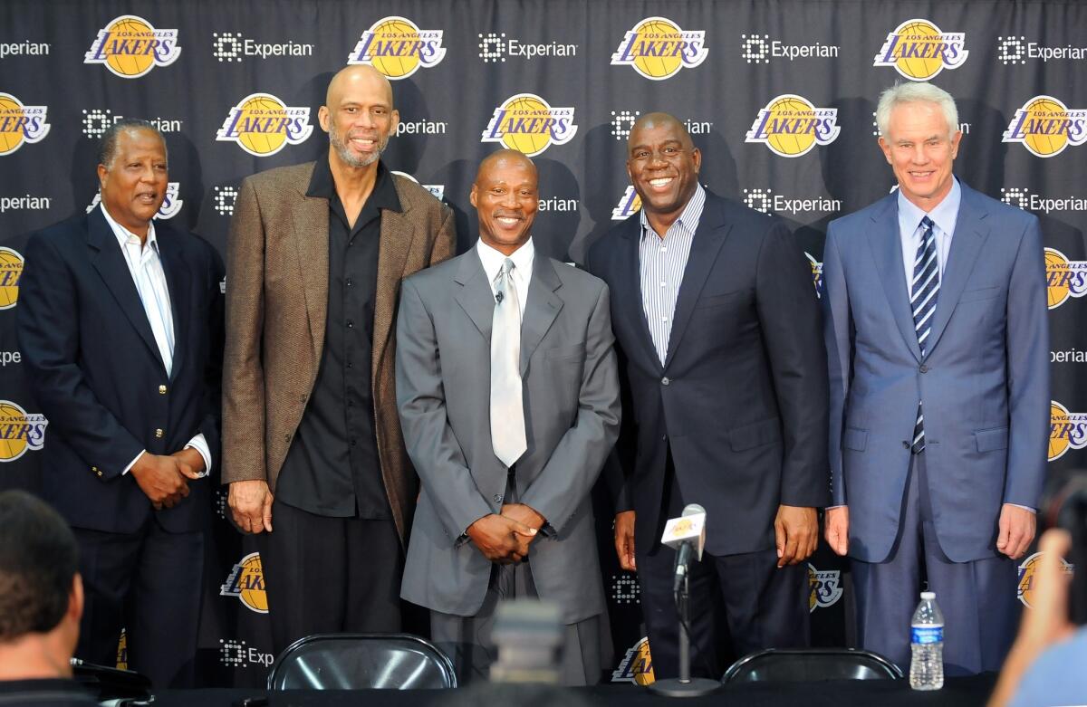 Lakers Coach Byron Scott, center, poses for photos with Lakers greats, left to right, Jamaal Wilkes, Kareem Abdul-Jabbar, Magic Johnson and General Manager Mitch Kupchak during a news conference in El Segundo on July 29.