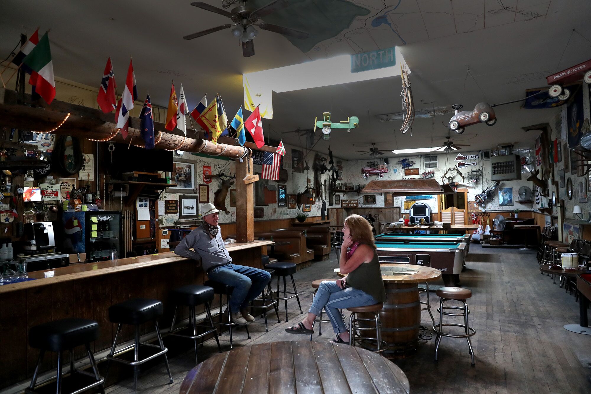Jake's Saloon owners Sherri Newman and Forrest Newman chat inside the Lone Pine, Calif., bar. To help make ends meet during the shutdown, Newman and her workers removed dollar-bill tips that had been stapled to the walls over the years.