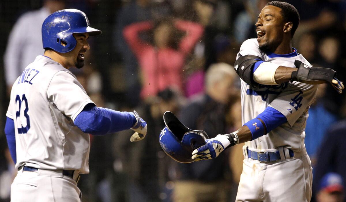 Dodgers second baseman Dee Gordon, right, celebrates with first baseman Adrian Gonzalez after scoring against the Cubs on a hit by Yasiel Puig in the seventh inning Thursday night in Chicago.