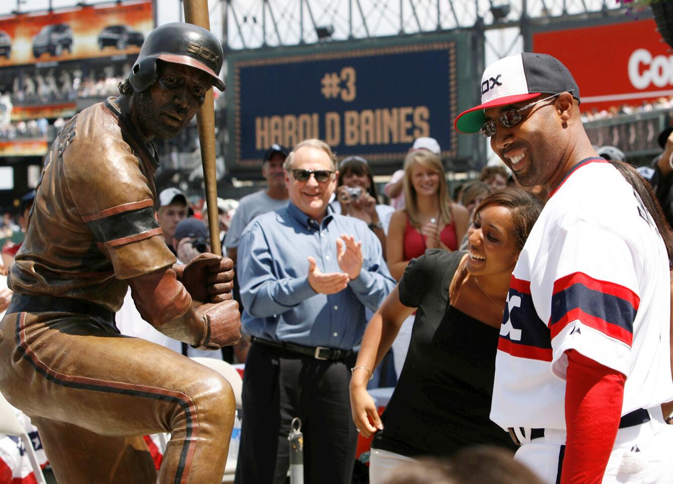 Harold Baines looks at his bronze statue with his daughter, Courtney, at U.S. Cellular Field on July 20, 2008. Jerry Reinsdorf, owner of the Chicago White Sox, claps in the background.