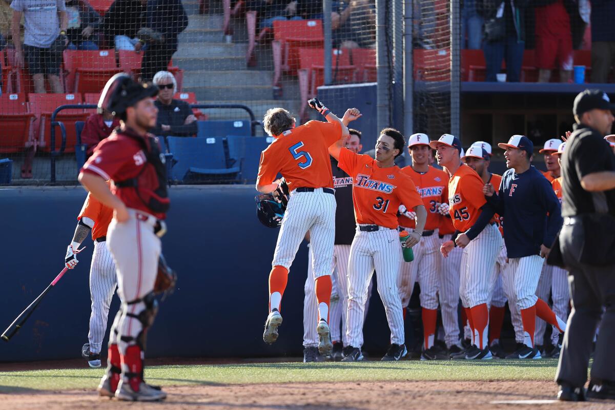 Cal State Fullerton's Caden Conner (5) celebrates with teammates during an 8-1 win over Stanford in February.