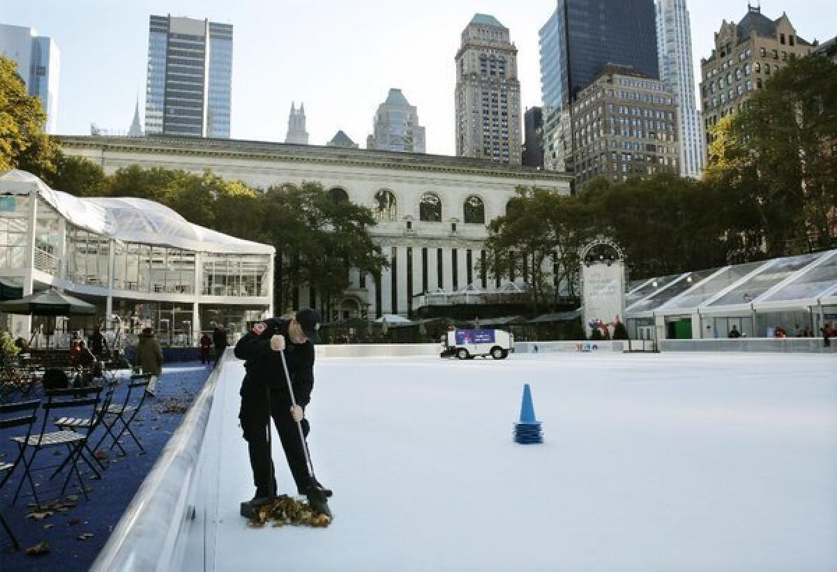 Debris is swept from the ice skating rink at Bryant Park in New York on Sunday. A shooting late Saturday sent a 14-year-old boy and 20-year-old man to the hospital.